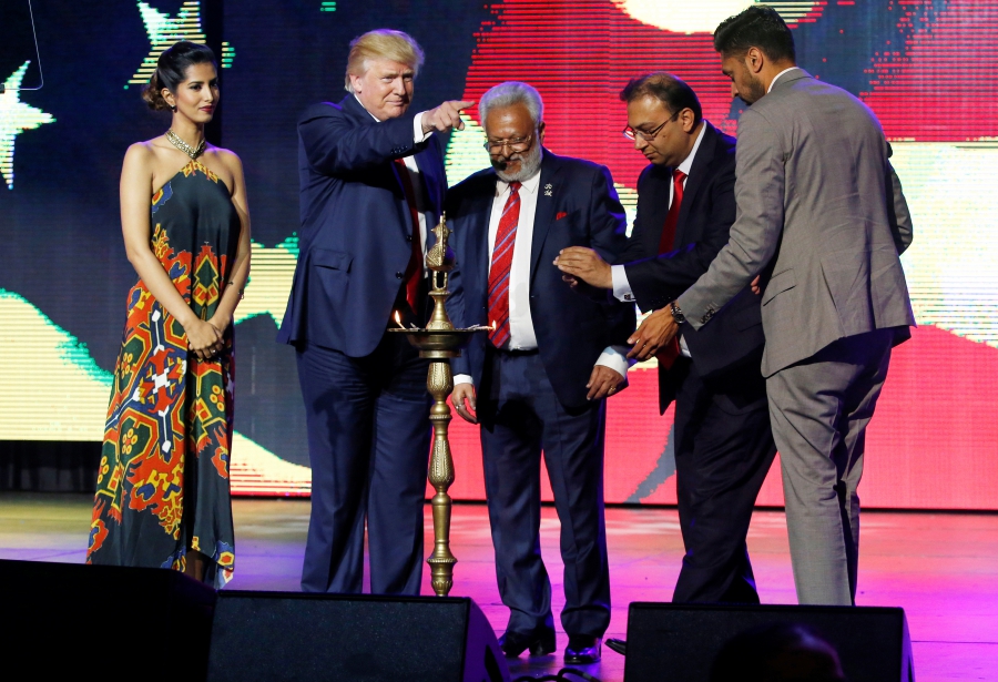 Republican Hindu Coalition Chairman Shalabh Kumar, center, stands with Republican presidential nominee Donald Trump to light a ceremonial diya lamp before he speaks to a crowd at a charity event hosted by the Republican Hindu Coalition in New Jersey. Credit: Jonathan Ernst/Reuters