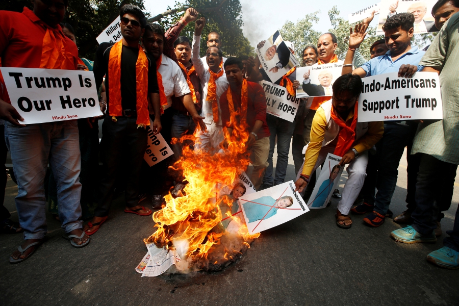 Members of Hindu Sena, a right wing Hindu group in India, burn posters of US Democratic presidential nominee Hillary Clinton during a protest against what they say is Clinton sabotaging Republican US presidential nominee Donald Trump's election campaign, in New Delhi, on October 18, 2016. Credit: Adnan Abidi/Reuters